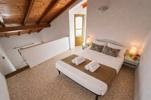 A bedroom with a bed, two bedside lamps, a window, and a door. - Our eco friendly home 2 min from Cabral Beach (Sal Rei)