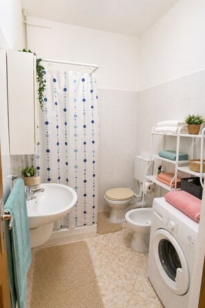 A compact bathroom with a toilet, sink, and washing machine. - Our eco friendly home 2 min from Cabral Beach (Sal Rei)