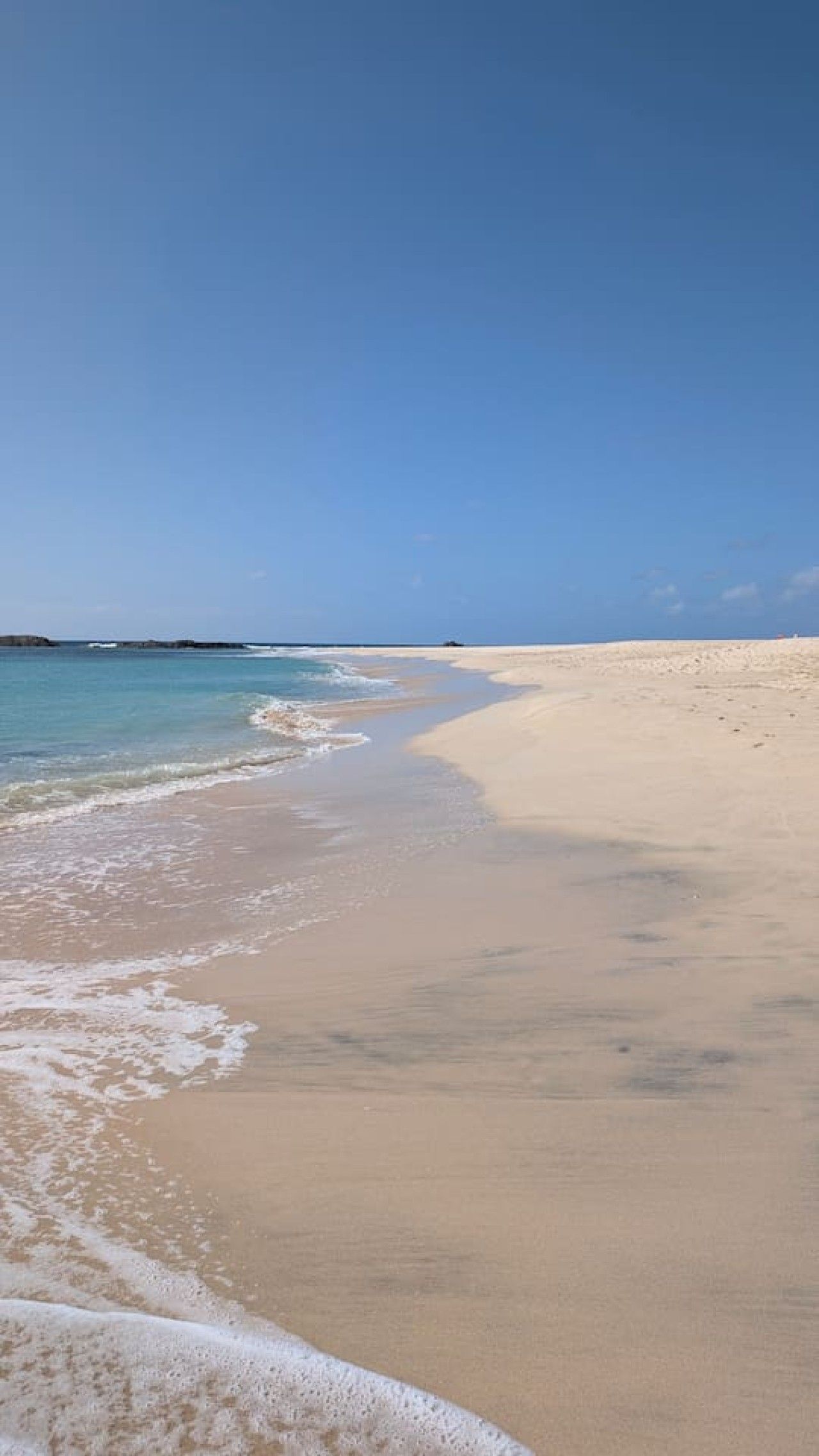 A beach with clear skies and calm waters.