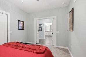Ein Schlafzimmer mit einem Bett, einer Tür zu einem Badezimmer und einem Flur.