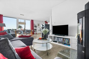 Un salon moderne avec un canapé, une table basse et un téléviseur à écran plat.