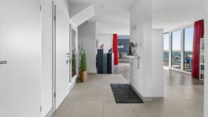 A modern interior with a hallway leading to a balcony with a view. - Maritimes & Sea – Vacation Home with Sauna and Ocean View on the Beach (Olpenitz)