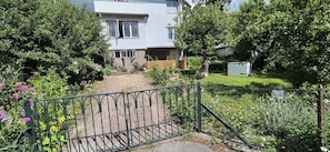 A residential property with a paved driveway leading to a house, surrounded by lush greenery and a metal gate. - Lovely 1-bedroom apartment in peaceful Stockholms perfect for relaxing (Stockholms)