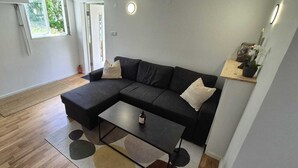 Uma sala de estar moderna com um sofá seccional, uma mesa de centro e um tapete pequeno.