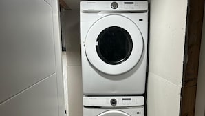 Une petite buanderie équipée de deux machines à laver superposées.