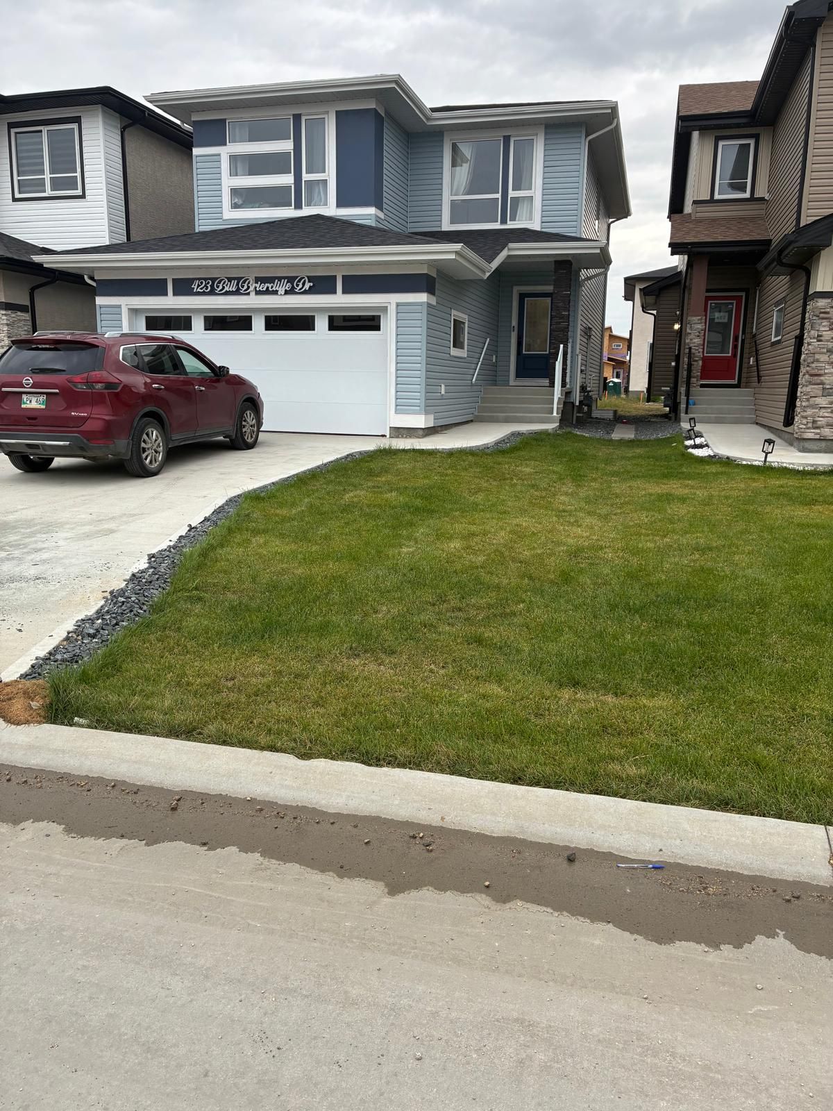 A residential property with a garage, a driveway, and a well-maintained lawn.