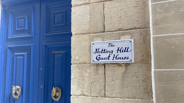 A blue door with a sign above it that reads 'The Notting Hill Guest House.'