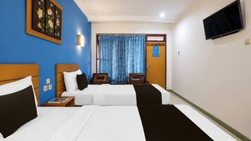 A hotel room with two beds, a television, a painting, and a window with curtains.