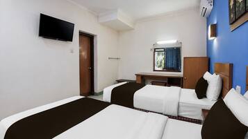 Habitación de hotel con dos camas, un escritorio, un espejo y una televisión.
