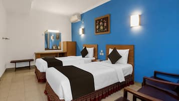 Habitación de hotel con dos camas, un escritorio, una silla y un espejo.