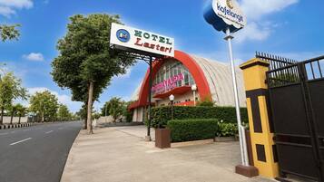 Un hotel con un letrero llamativo, una entrada porticada y un cielo despejado.