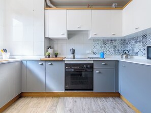 A modern kitchen with grey cabinets, a dishwasher, and a microwave. - Apartment Uolas by Interhome (Salou)