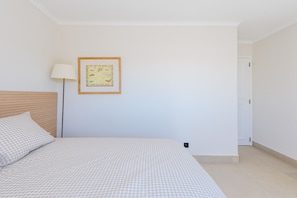 Un dormitorio con una cama, una lámpara y un cuadro en la pared.