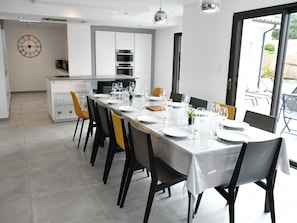 Un comedor moderno con una mesa larga dispuesta para seis personas, rodeada de sillas con tapicería negra y amarilla.
