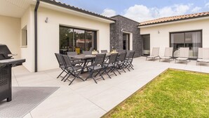 A patio with a dining table and chairs, a grill, and a small garden area. - Spacious house in a quiet area (La Haie-Fouassière)