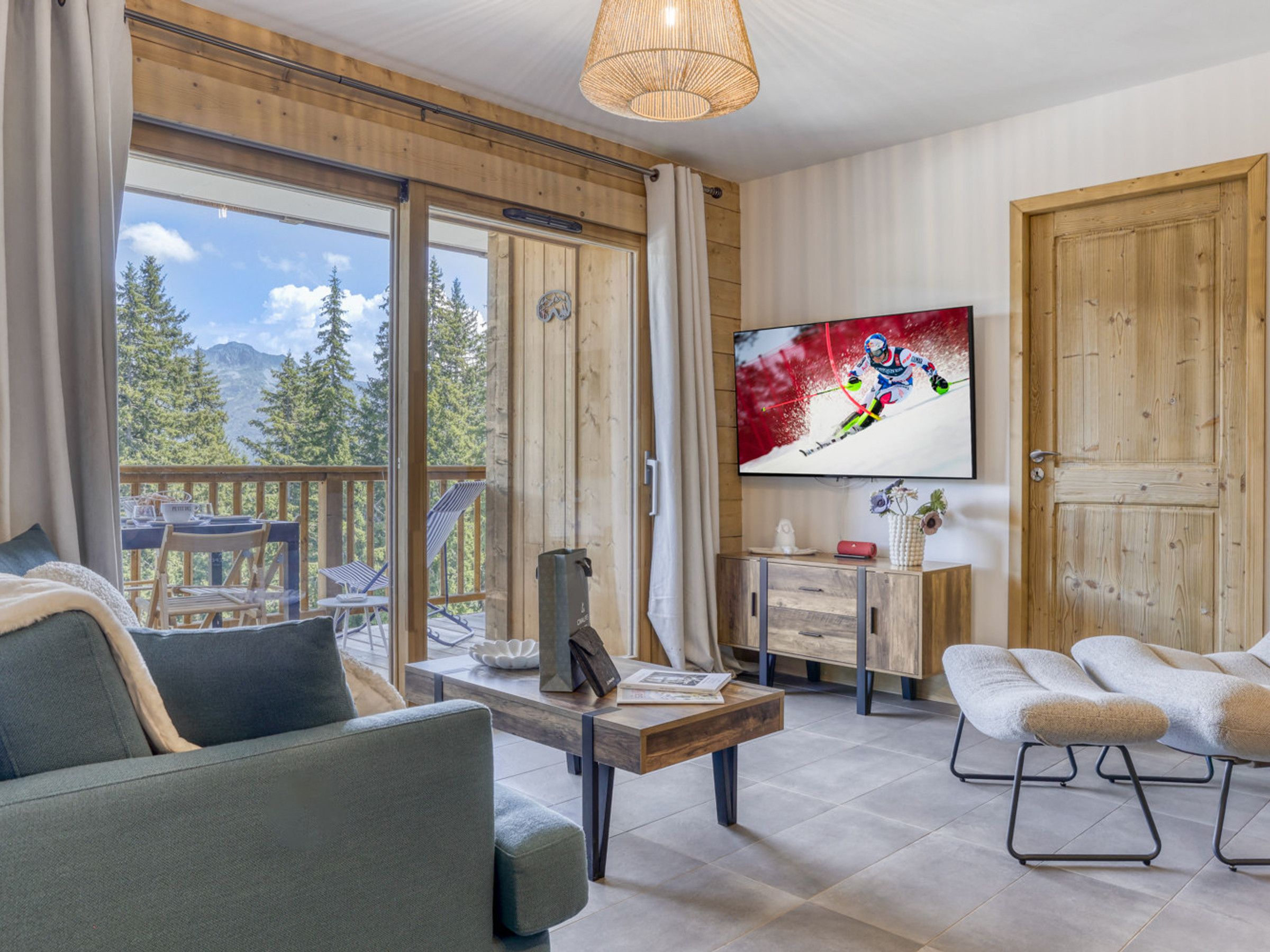A modern living room with a sofa, a coffee table, and a television mounted on the wall.