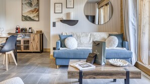 En moderne stue med en blå sofa, et sofabord og et spiseområde med et træskab.