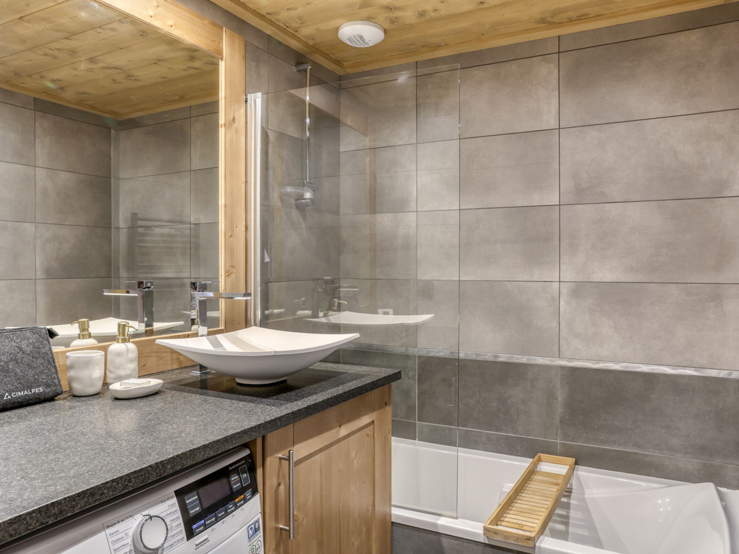 A modern bathroom with a freestanding bathtub, a glass shower enclosure, and a vanity with a sink and mirror.