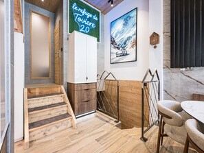 A modern interior with a staircase, wooden flooring, a white cabinet, a neon sign, and a framed picture on the wall. - Luxury apartment - 10 guests (Tignes)