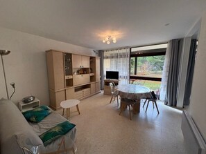 A room with a bed, a desk, a TV, and a dining table. - Apartment with AC, private parking - 4 guests (Balaruc-les-Bains)