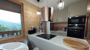 Eine moderne Küche mit Einbauofen, Kaffeemaschine und Schneidebrett.