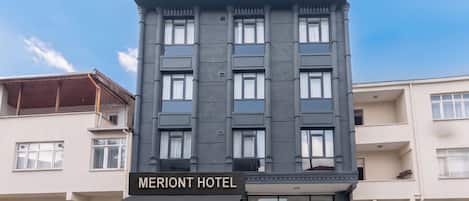 A multi-story hotel building with a prominent sign reading 'MERIANT HOTEL'.