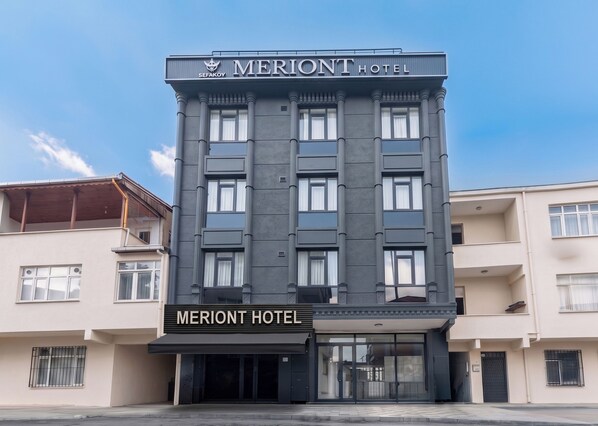 A multi-story hotel building with a prominent sign reading 'MERIANT HOTEL'.