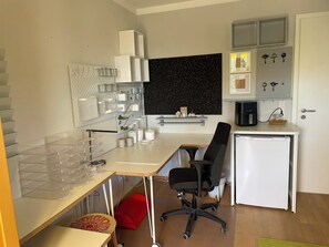 A modern kitchen with a white countertop, a black office chair, a small white refrigerator, and a black backsplash. - Studio Balcon Douceur - Sanftheit, stilvoll, Pantry Küche, Balkon, Garten & Pool (Rain)