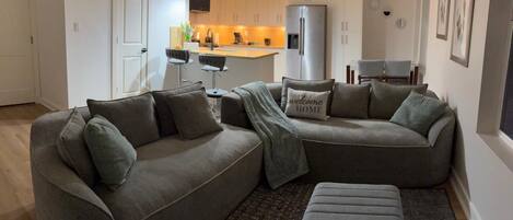 A modern living room with a sectional sofa, a coffee table, and a rug.