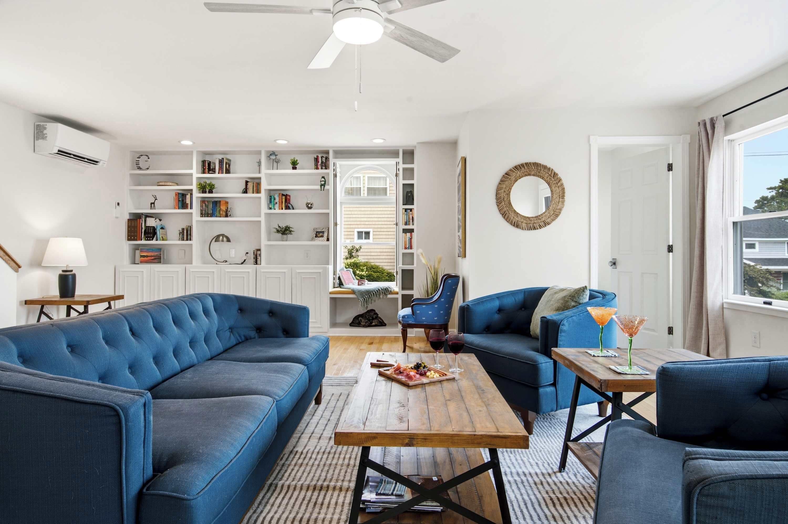 A modern living room with a sectional sofa, a wooden coffee table, and a bookshelf filled with books and decorative items.