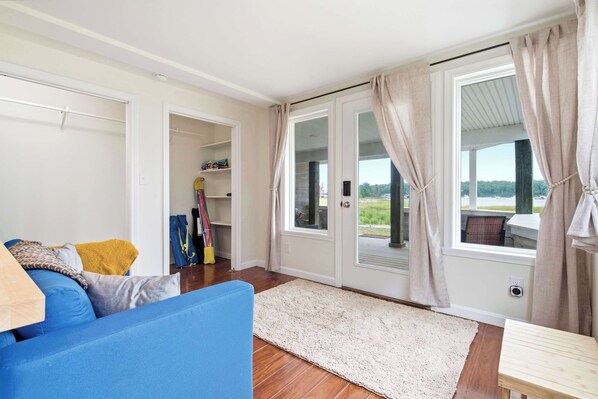 Una habitación con un sofá azul, un tapete blanco y vistas al exterior a través de un ventanal.