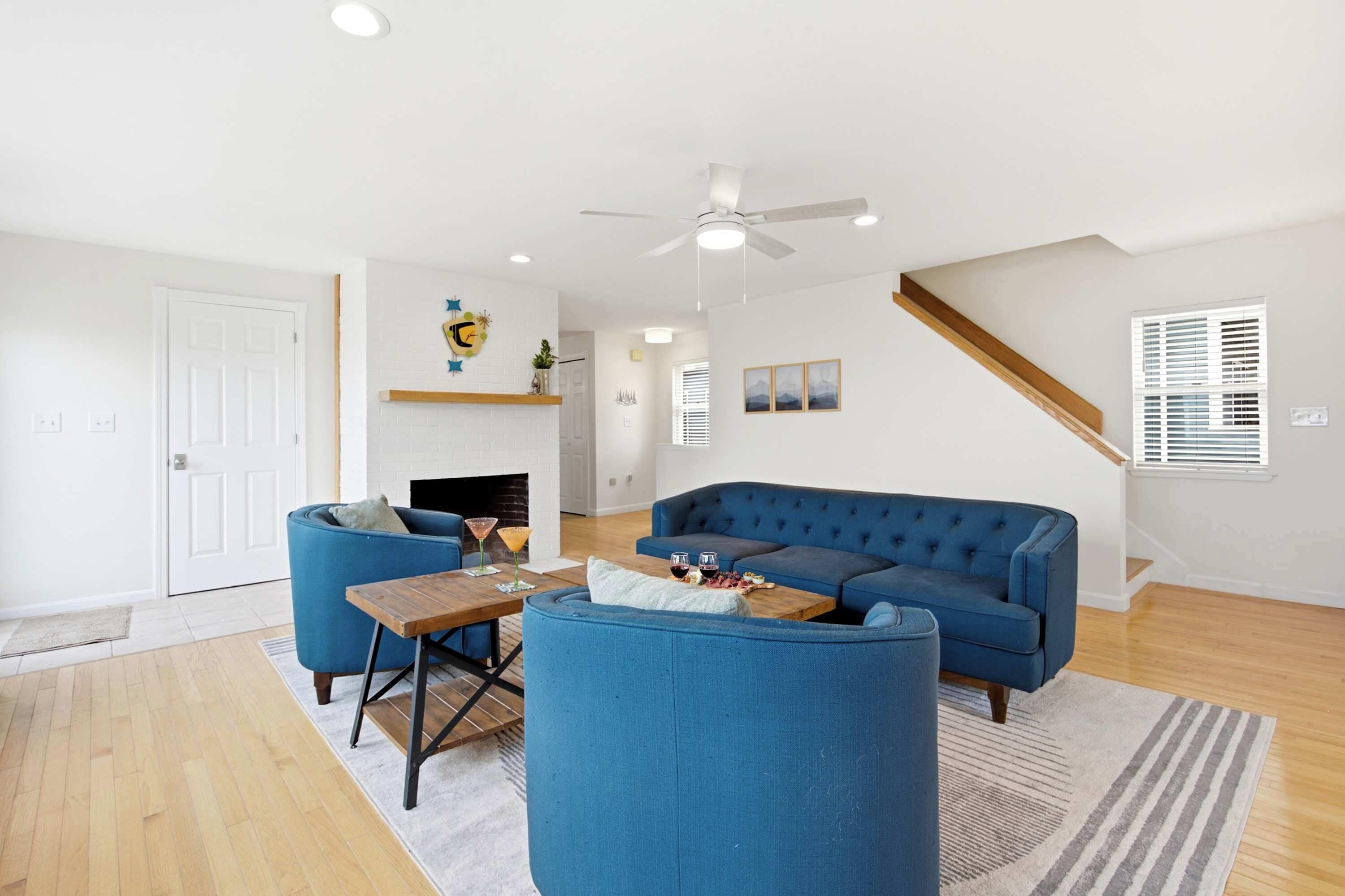 A modern living room with a blue sofa, a wooden coffee table, and a fireplace.