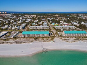 Un hotel costero con varias construcciones, una playa y una vista despejada del océano.