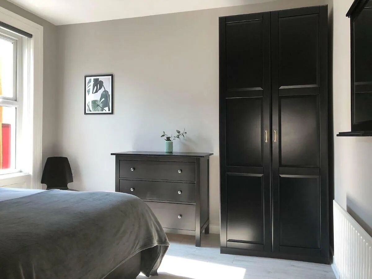 Une chambre à coucher avec un lit, une commode, une armoire et une fenêtre.