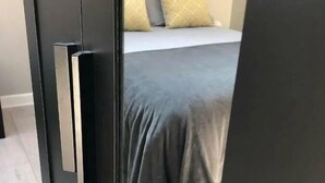 A bedroom with a bed, pillows, and a door. - Spacious 3-Bed Apartment in Queen's Quarter (Belfast)