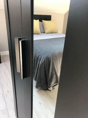 A bedroom with a bed, pillows, and a door. - Spacious 3-Bed Apartment in Queen's Quarter (Belfast)