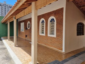 Un edifici amb façana de maó, marcaments de finestra blancs i sòl de rajola.