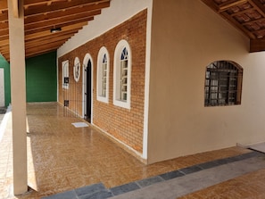 Un espacio al aire libre cubierto con piso de baldosas, paredes de ladrillo y ventanas en arco.