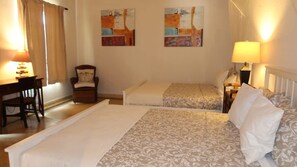 A hotel room with two beds, a desk, a chair, and two wall-mounted paintings. - Caribbean Bungallow With 2 Bedrooms in Cap Cana (Punta Cana)