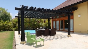 A covered outdoor area with a pool, patio furniture, and a pergola. - Caribbean Bungallow With 2 Bedrooms in Cap Cana (Punta Cana)