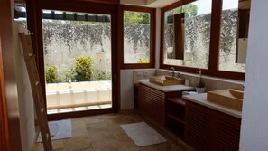 A bathroom with a large window, a sink, and a mirror. - Caribbean Bungallow With 2 Bedrooms in Cap Cana (Punta Cana)