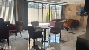 A modern hotel lobby with a mix of seating areas, a reception desk, and large windows offering views of the outside. - Armada Hotel (İstanbul)