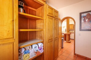 Ein Holzkabinent mit Regalen und einer unteren Ablage für gefaltete Handtücher.