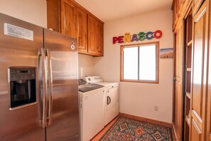 A compact kitchen with a stainless steel refrigerator, a washing machine, and a coffee maker. - Hacienda Almas Gemelas – Where Luxury Meets the Sea of Cortez (Puerto Peñasco)