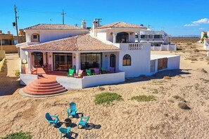 A coastal property with a patio area, outdoor seating, and a view of the beach. - Hacienda Almas Gemelas – Where Luxury Meets the Sea of Cortez (Puerto Peñasco)