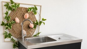 Un armari de cuina negre amb un vàter d'acer inoxidable i dos calaixos.