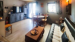 Una sala de estar acogedora con un sofá, una mesa de centro y un comedor con sillas y una mesa.