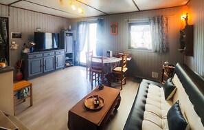 Ein gemütliches Wohnzimmer mit Sofa, Couchtisch und einem Essbereich mit Stühlen und Tisch.