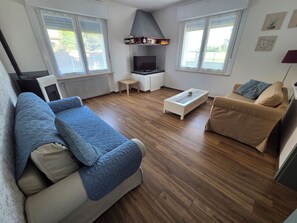 Un salon avec un canapé, une table basse et un meuble pour la télévision.