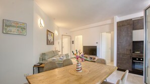 Eine moderne Küche mit Essbereich, einer Couch und einem Gemälde an der Wand.